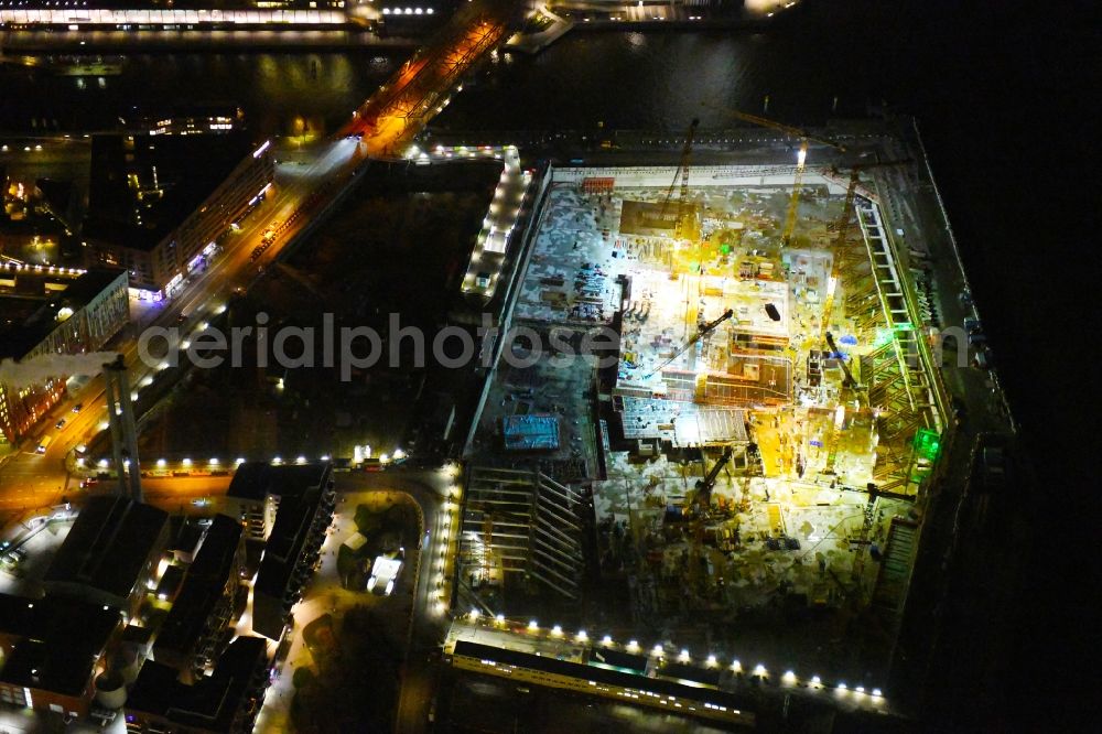 Aerial photograph at night Hamburg - Night lighting construction site for the new building complex of the shopping center at Ueberseequartier at Chicagokai - Osakaallee in the area of the former Grasbrooks in the Hafencity district in Hamburg, Germany