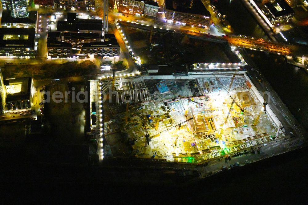 Hamburg at night from above - Night lighting construction site for the new building complex of the shopping center at Ueberseequartier at Chicagokai - Osakaallee in the area of the former Grasbrooks in the Hafencity district in Hamburg, Germany