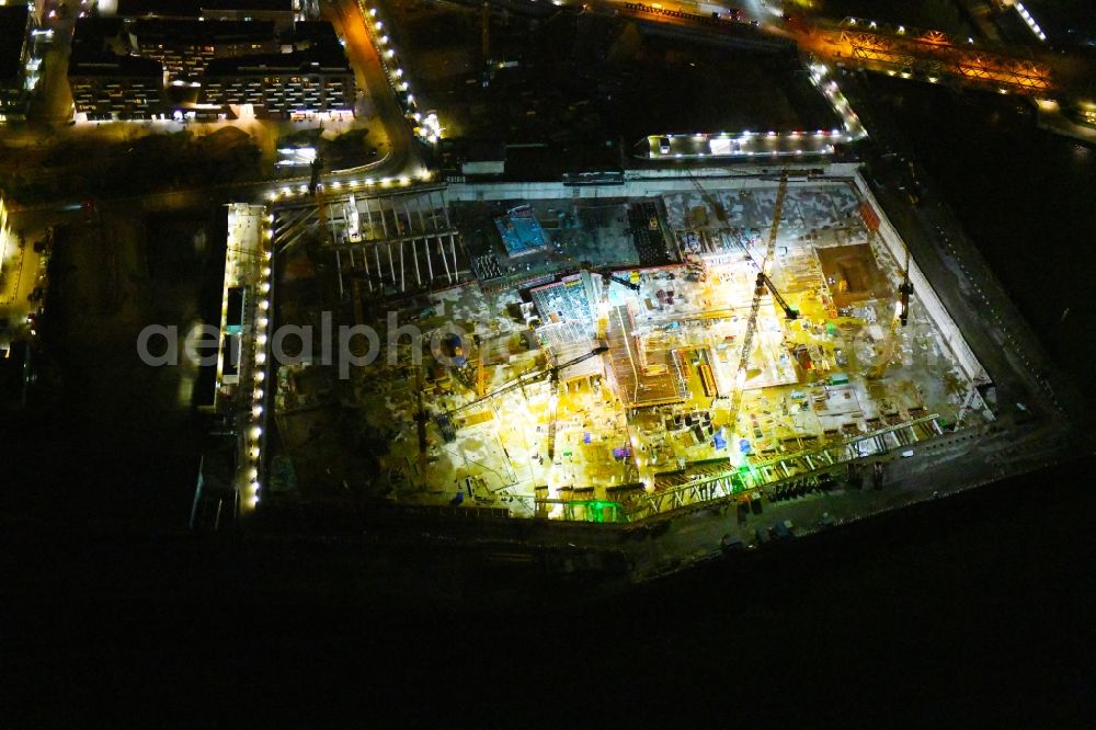 Hamburg at night from the bird perspective: Night lighting construction site for the new building complex of the shopping center at Ueberseequartier at Chicagokai - Osakaallee in the area of the former Grasbrooks in the Hafencity district in Hamburg, Germany