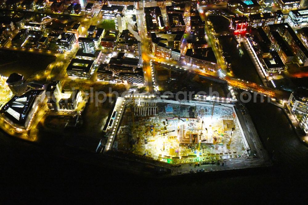 Aerial image at night Hamburg - Night lighting construction site for the new building complex of the shopping center at Ueberseequartier at Chicagokai - Osakaallee in the area of the former Grasbrooks in the Hafencity district in Hamburg, Germany