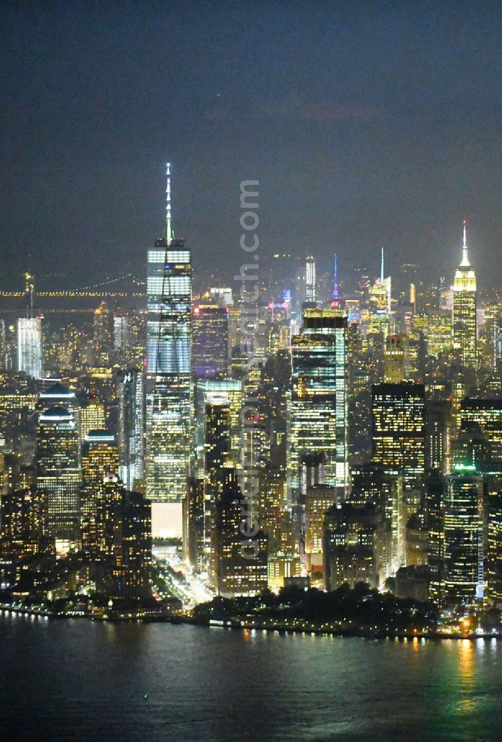 New York at night from the bird perspective: Night lighting City center with One World Trade Center in the skyline in the downtown area in the district Manhattan in New York in United States of America