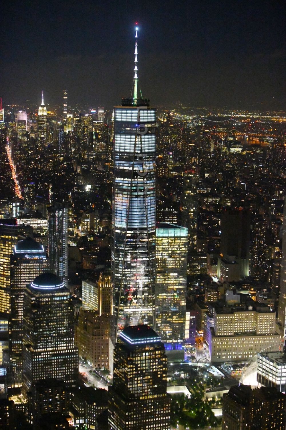 Aerial image at night New York - Night lighting City center with One World Trade Center in the skyline in the downtown area in the district Manhattan in New York in United States of America