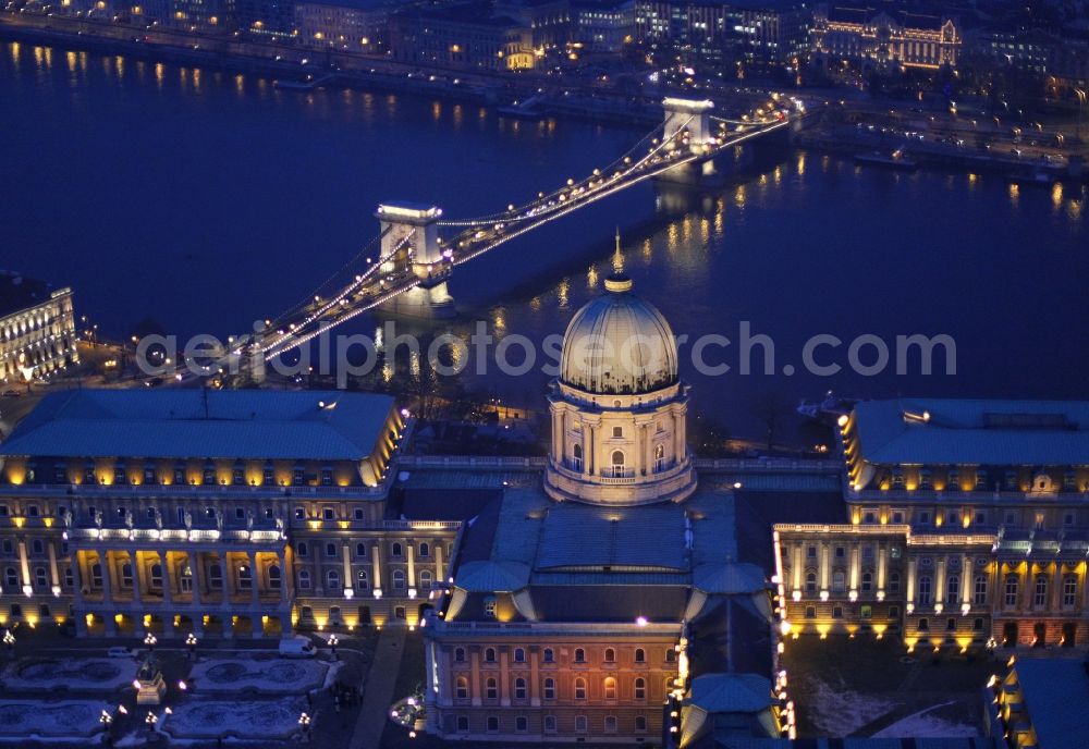 Aerial photograph at night Budapest - Night lights and lighting Palace of the Royal Palace with the chain bridge over the Danube in Budapest in Hungary