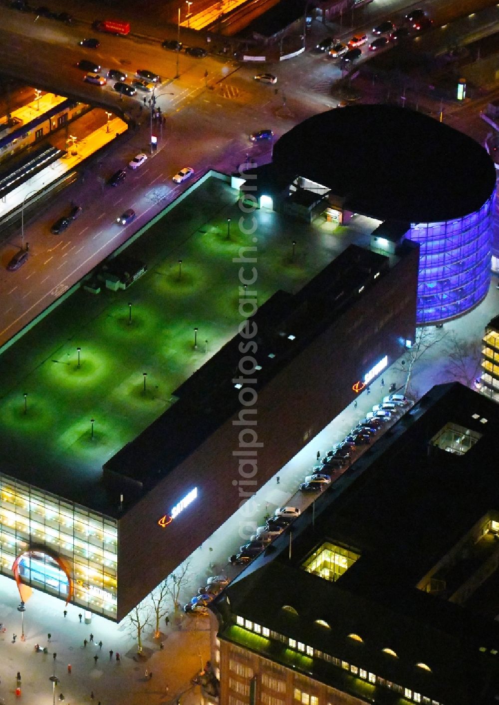 Hamburg at night from the bird perspective: Night lighting purple - pink night lighting from the parking deck to the building of the parking garage SATURN in Moenckebergstrasse in Hamburg