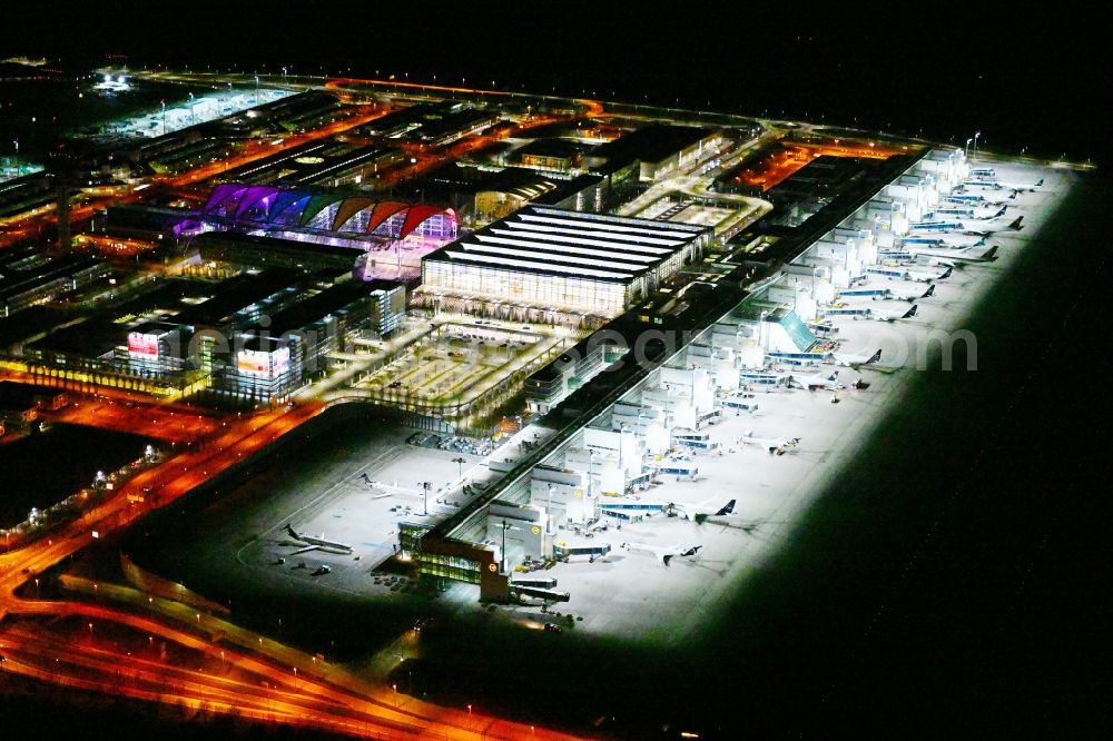 München-Flughafen at night from the bird perspective: Night lighting dispatch building and terminals on the premises of the airport in Muenchen-Flughafen in the state Bavaria, Germany