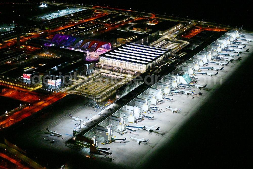 Aerial image at night München-Flughafen - Night lighting dispatch building and terminals on the premises of the airport in Muenchen-Flughafen in the state Bavaria, Germany