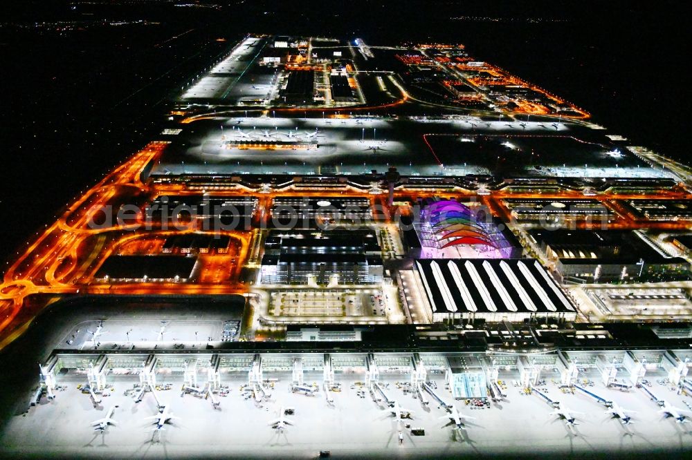 Aerial photograph at night München-Flughafen - Night lighting dispatch building and terminals on the premises of the airport in Muenchen-Flughafen in the state Bavaria, Germany