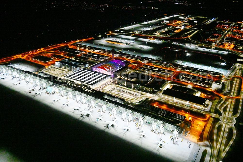 Aerial photograph at night München-Flughafen - Night lighting dispatch building and terminals on the premises of the airport in Muenchen-Flughafen in the state Bavaria, Germany