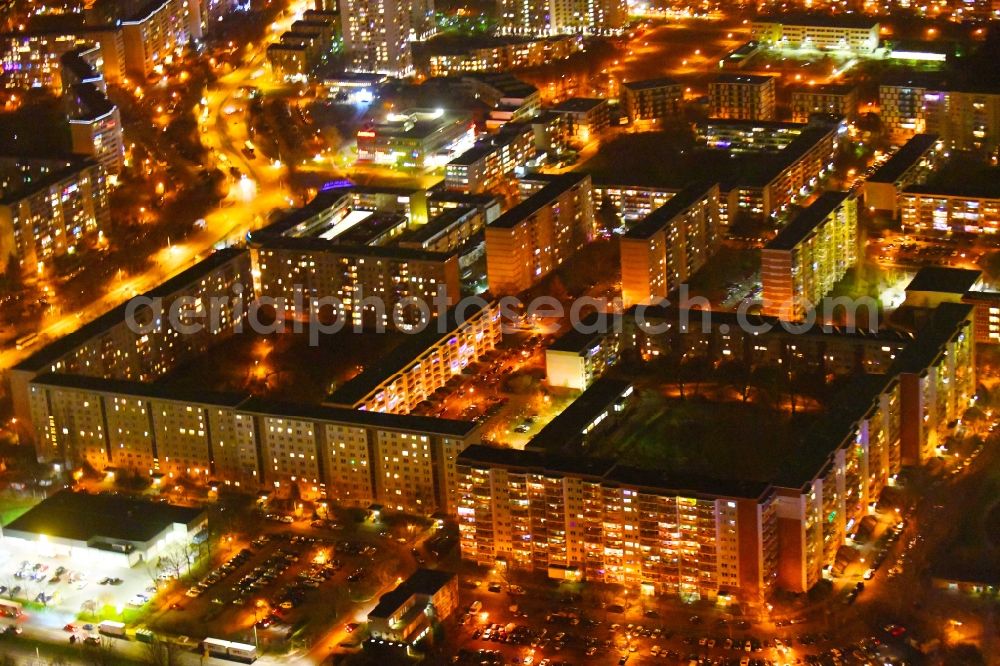 Aerial photograph at night Berlin - Night lighting skyscrapers in the residential area of industrially manufactured settlement along the Walter-Felsenstein-Strasse - Mehrower Allee in the district Marzahn in Berlin, Germany