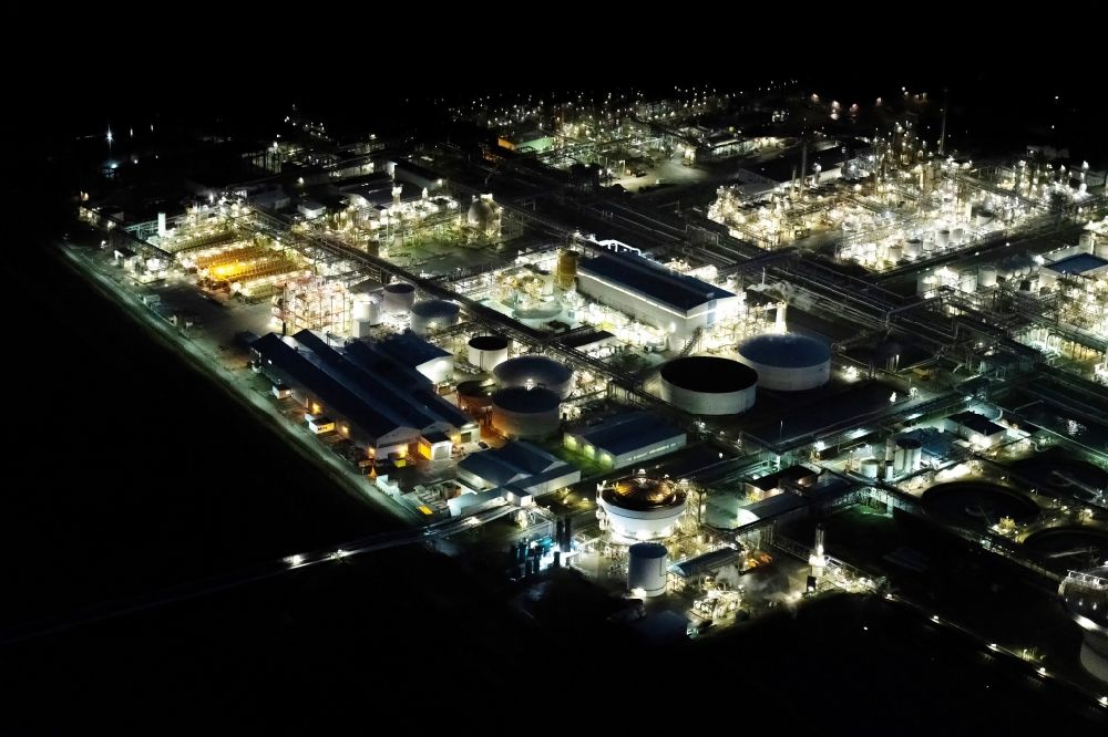 Aerial photograph at night Stade - Night lighting refinery equipment and management systems on the factory premises of the chemical manufacturers of Fa. Dow Chemical Olin in Stade in the state Lower Saxony, Germany