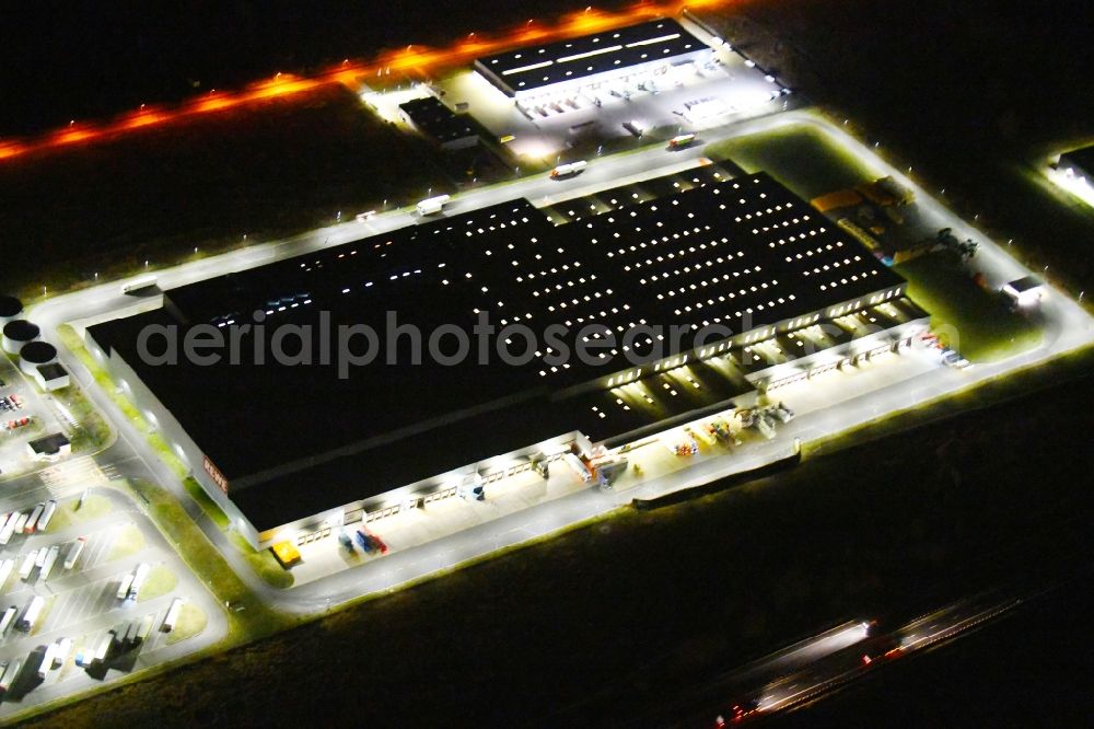 Aerial photograph at night Oranienburg - Night lighting Warehouses and forwarding building of REWE- Logistikzentrum on Rewestrasse in the district Borgsdorf in Oranienburg in the state Brandenburg, Germany