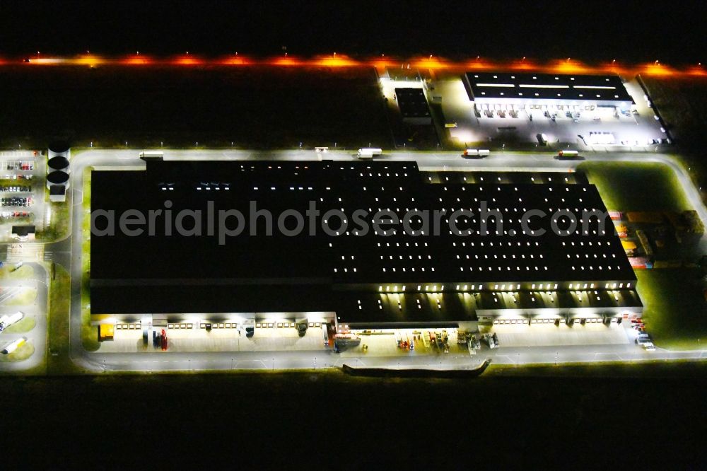 Oranienburg at night from the bird perspective: Night lighting Warehouses and forwarding building of REWE- Logistikzentrum on Rewestrasse in the district Borgsdorf in Oranienburg in the state Brandenburg, Germany