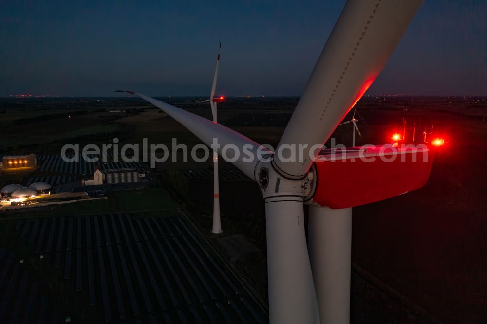 Aerial photograph at night Bliesdorf - Night lights and anti-collision lighting of the rotor heads and wind turbine tube towers of wind turbines (WEA) rise up in a field in Bliesdorf in the state of Brandenburg, Germany