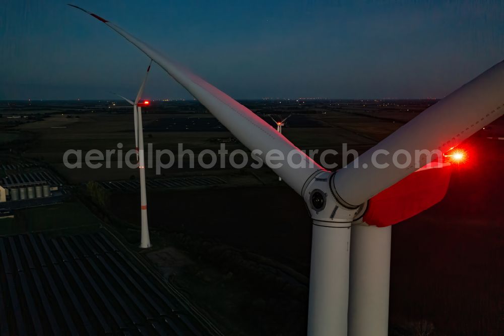 Aerial image at night Bliesdorf - Night lights and anti-collision lighting of the rotor heads and wind turbine tube towers of wind turbines (WEA) rise up in a field in Bliesdorf in the state of Brandenburg, Germany