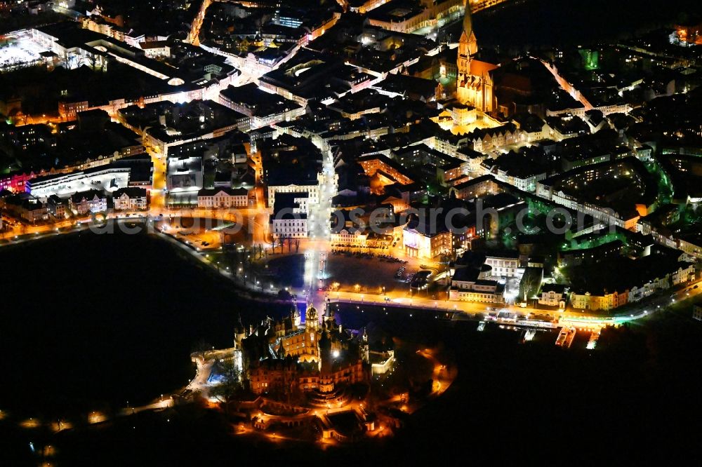 Aerial image at night Schwerin - Night lights and illumination of the domed towers of the Schwerin Castle and the Castle Church in the castle garden on the Burgsee on the Castle Island, the seat of the state parliament in the state capital of Schwerin in Mecklenburg-Western Pomerania