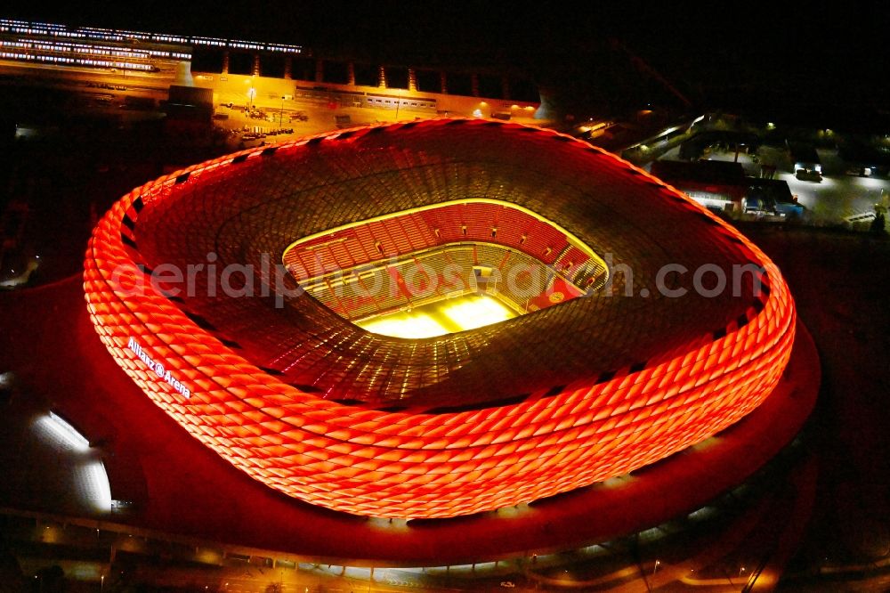 München at night from the bird perspective: Night lighting sports facility grounds of the Arena stadium Allianz Arena on Werner-Heisenberg-Allee in Munich in the state Bavaria, Germany
