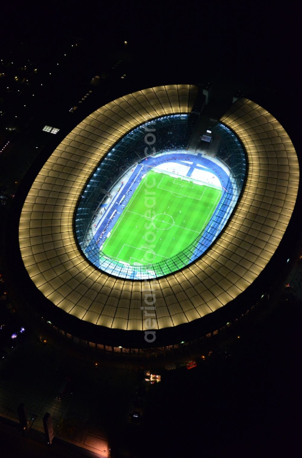 Berlin at night from the bird perspective: Night lighting Sports facility grounds of the Arena stadium Olympiastadion of Hertha BSC in Berlin in Germany