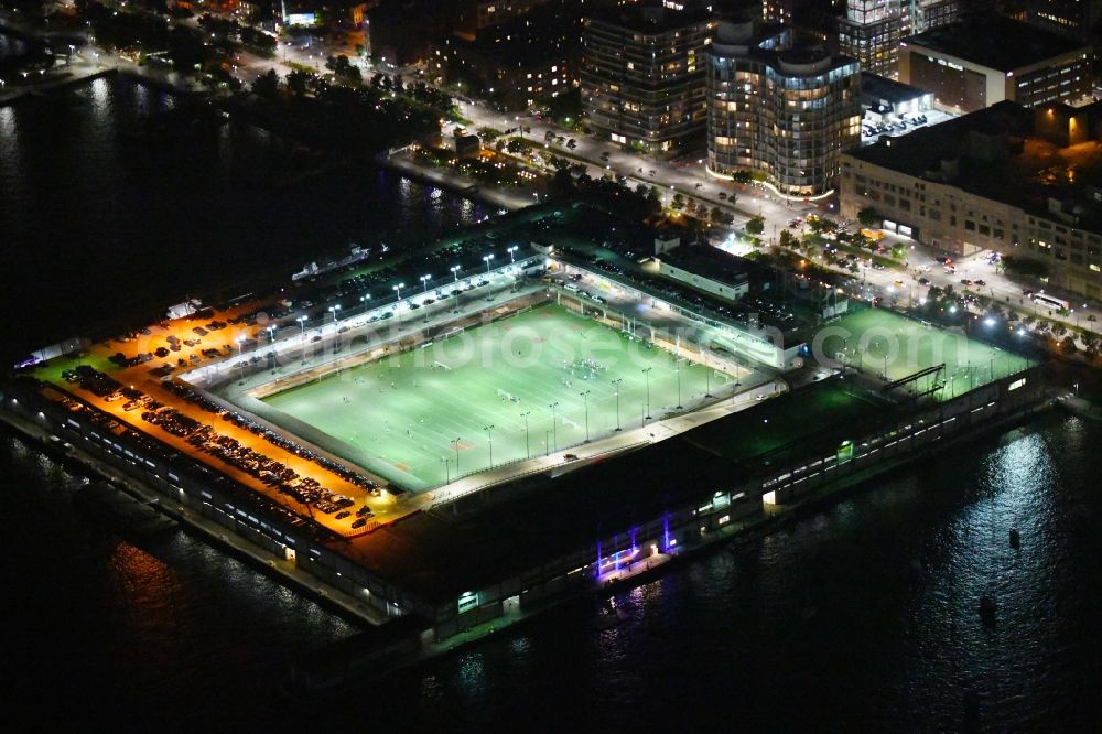 Aerial photograph at night New York - Night lighting Sports facility grounds of the Arena stadium Pier 40 at Soccer Field on Hudson River Park in the district Manhattan in New York in United States of America