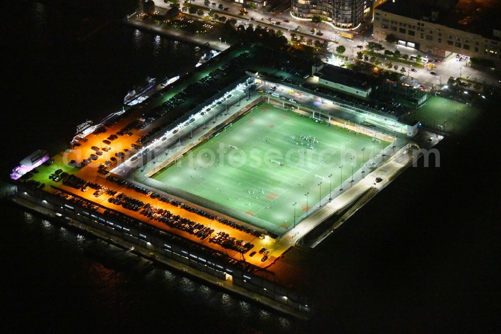 Aerial image at night New York - Night lighting Sports facility grounds of the Arena stadium Pier 40 at Soccer Field on Hudson River Park in the district Manhattan in New York in United States of America