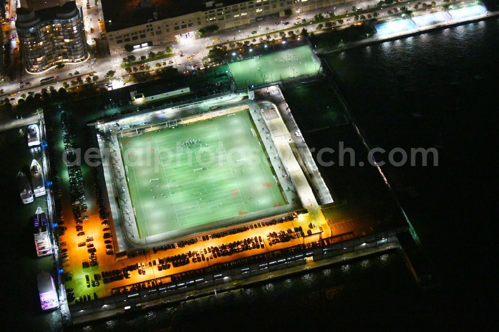 Aerial photograph at night New York - Night lighting Sports facility grounds of the Arena stadium Pier 40 at Soccer Field on Hudson River Park in the district Manhattan in New York in United States of America