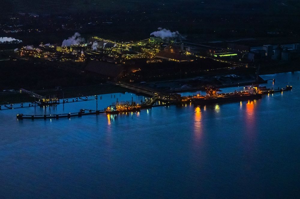 Stade at night from the bird perspective: Night lighting port facility Stader Seehafen AOS am Buetzflether Sand in Buetzfleth in the state Lower Saxony, Germany. The Hanseatic Energy Hub is to be built on the green space by 2026. The planned terminal for the import of liquefied natural gas (LNG) will be integrated into the existing industrial park