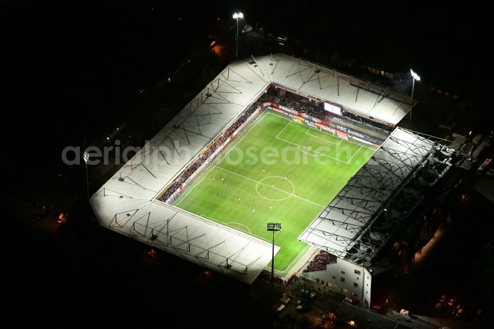Berlin at night from above - Night lighting view of the football stadium Alte Foersterei with its new grandstand the district of Koepenick in Berlin. The pitch is homestead for the football games of FC Union Berlin