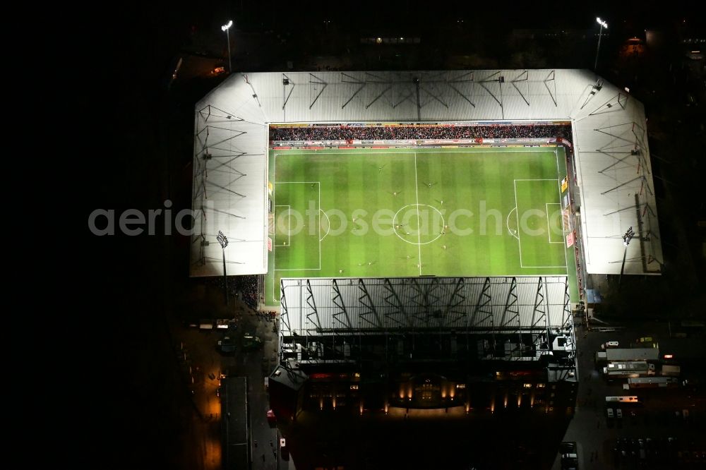 Berlin at night from above - Night lighting view of the football stadium Alte Foersterei with its new grandstand the district of Koepenick in Berlin. The pitch is homestead for the football games of FC Union Berlin