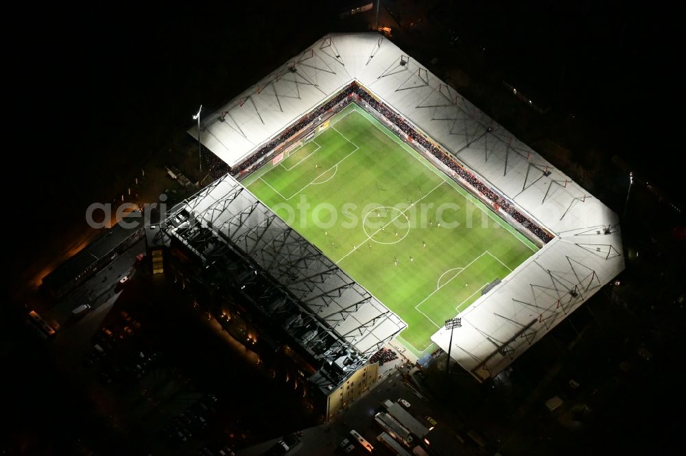 Aerial photograph at night Berlin - Night lighting view of the football stadium Alte Foersterei with its new grandstand the district of Koepenick in Berlin. The pitch is homestead for the football games of FC Union Berlin