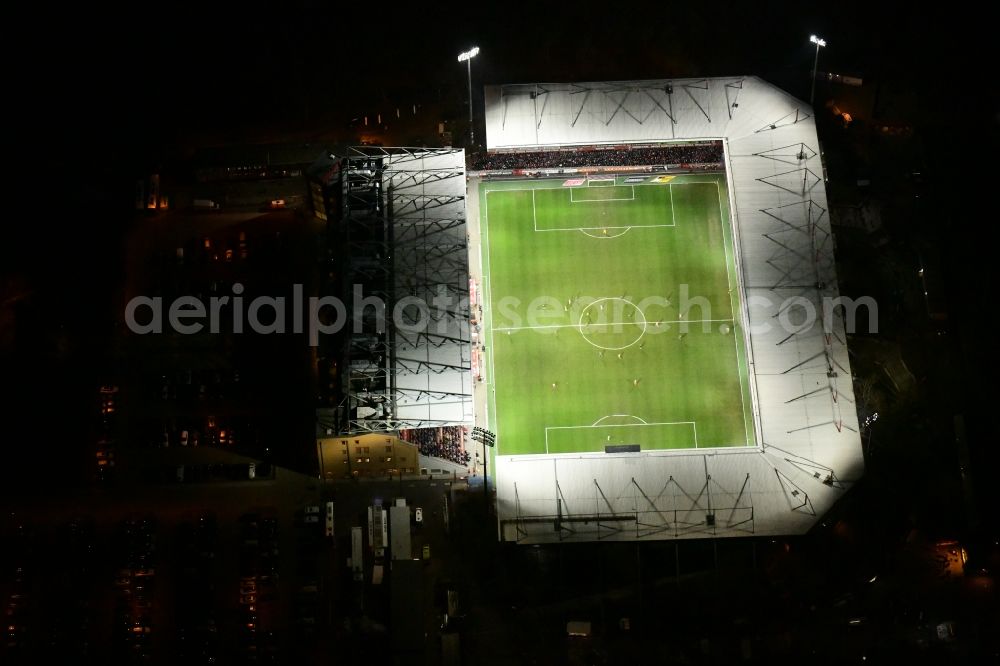 Aerial image at night Berlin - Night lighting view of the football stadium Alte Foersterei with its new grandstand the district of Koepenick in Berlin. The pitch is homestead for the football games of FC Union Berlin
