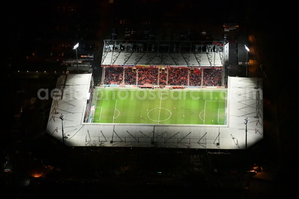 Aerial photograph at night Berlin - Night lighting view of the football stadium Alte Foersterei with its new grandstand the district of Koepenick in Berlin. The pitch is homestead for the football games of FC Union Berlin