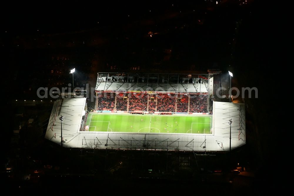 Aerial image at night Berlin - Night lighting view of the football stadium Alte Foersterei with its new grandstand the district of Koepenick in Berlin. The pitch is homestead for the football games of FC Union Berlin