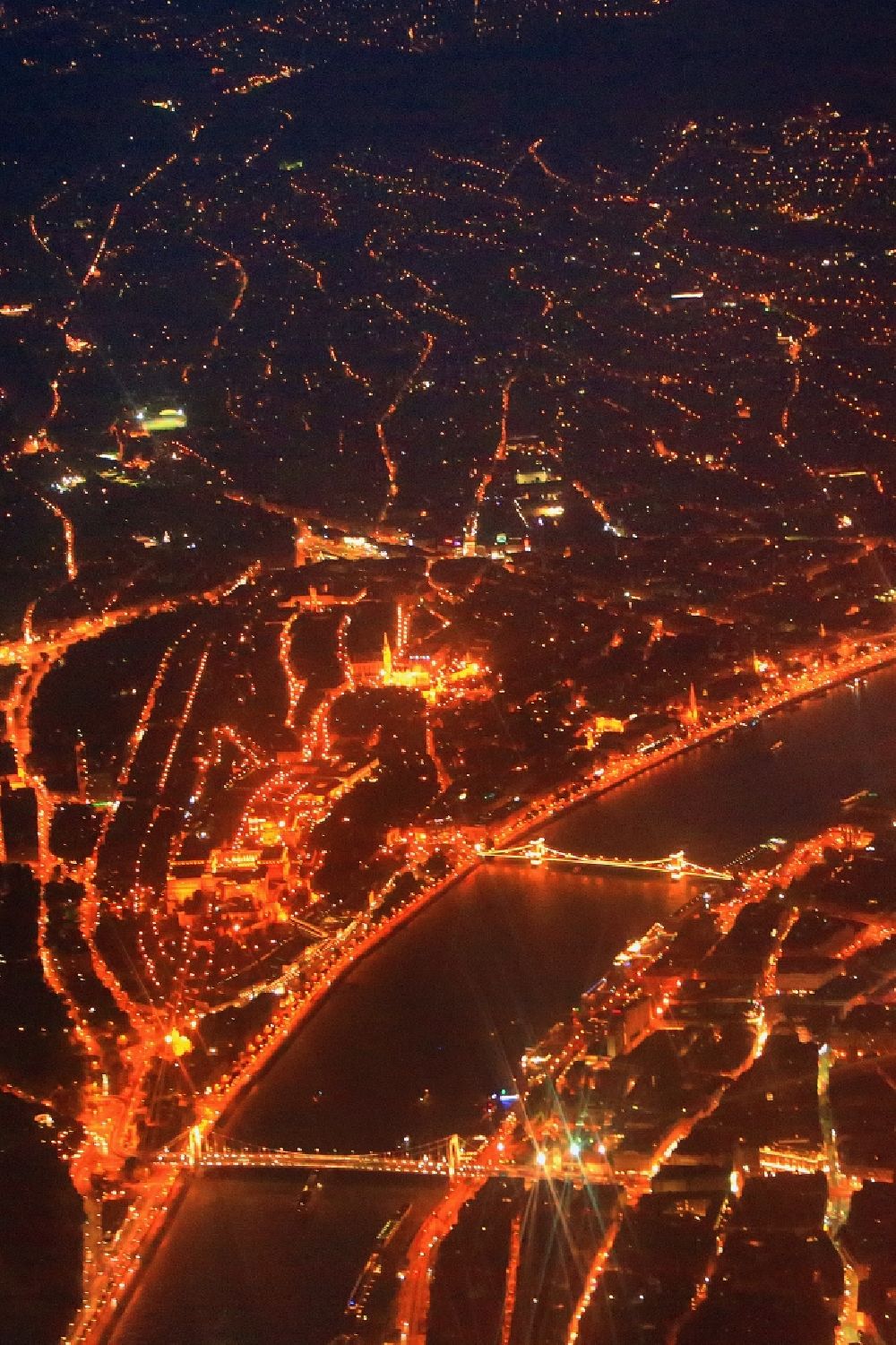 Aerial image at night Budapest - Night lighting city view on the river bank of the river Danube in Budapest in Hungary