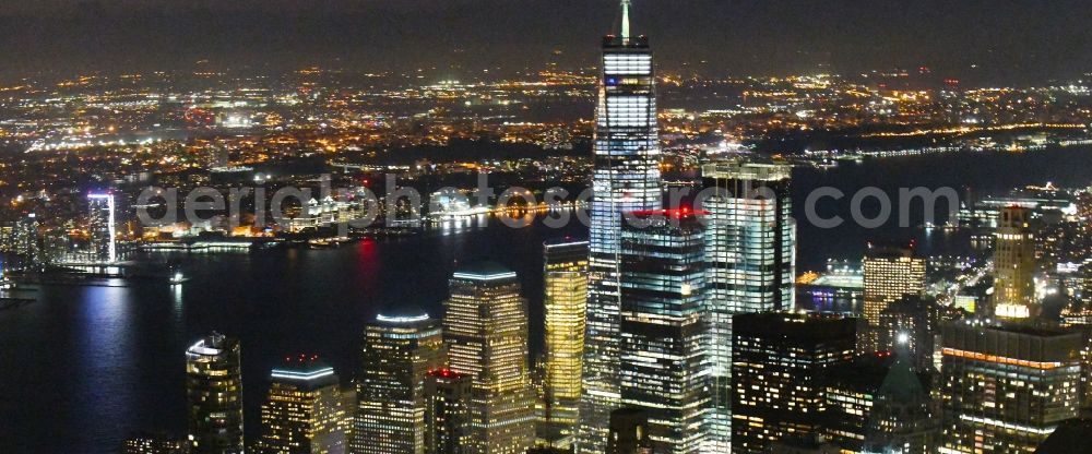 Aerial photograph at night New York - Night lighting City center with the skyline in the downtown area in the district Manhattan in New York in United States of America