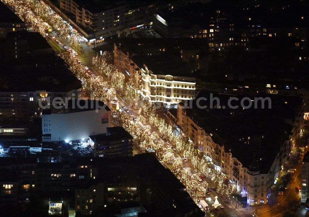 Aerial photograph at night Berlin - Night vies street guide of famous promenade and shopping street Kurfuerstendamm with illuminated trees in the district Charlottenburg-Wilmersdorf in Berlin