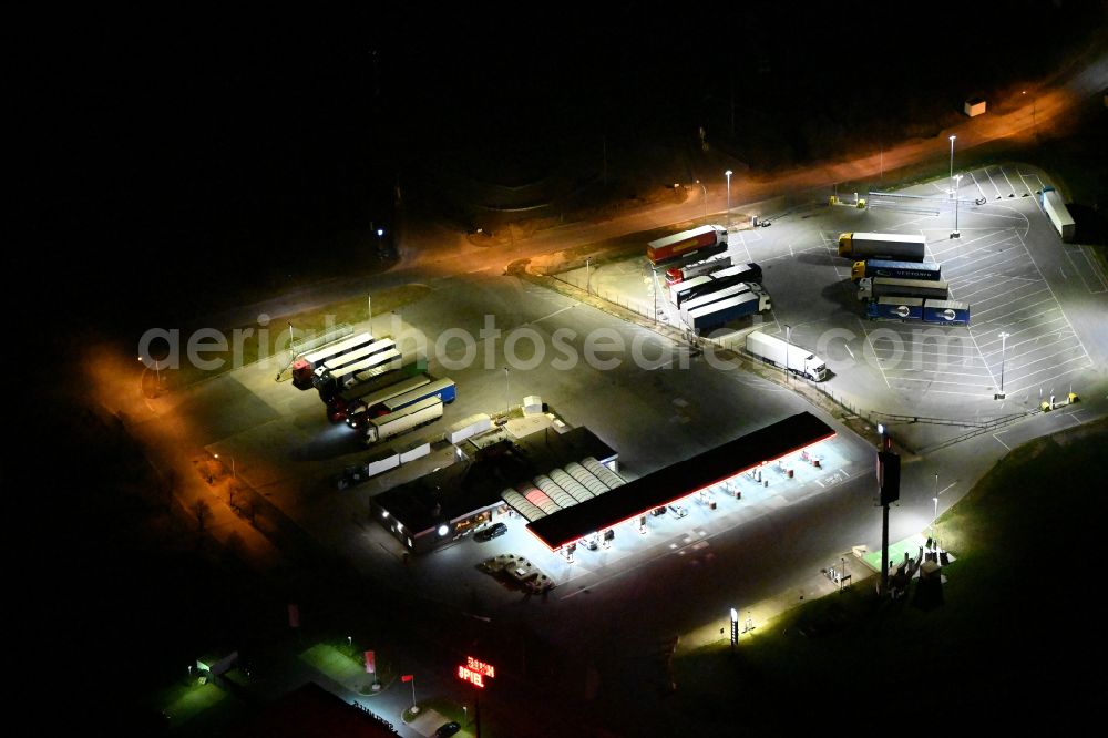 Aerial photograph at night Kleinhelmsdorf - Night lighting gas station TotalEnergies Autohof for sale of petrol and diesel fuels and mineral oil trade on street Im Heidegrund Sued - Lindenstrasse in Kleinhelmsdorf in the state Saxony-Anhalt, Germany