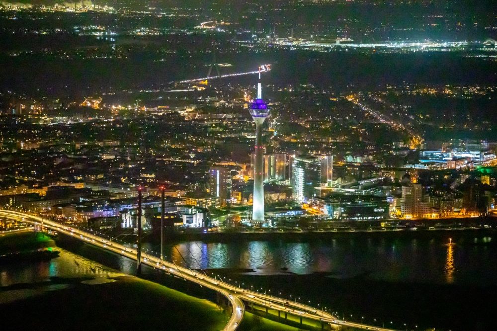 Düsseldorf at night from the bird perspective: Night lighting Riverside areas on the Rheinbogen in the area of a??a??the Rheinkniebruecke overlooking the top of the Television Tower Rheinturm and the city center in the background in Duesseldorf in the state North Rhine-Westphalia