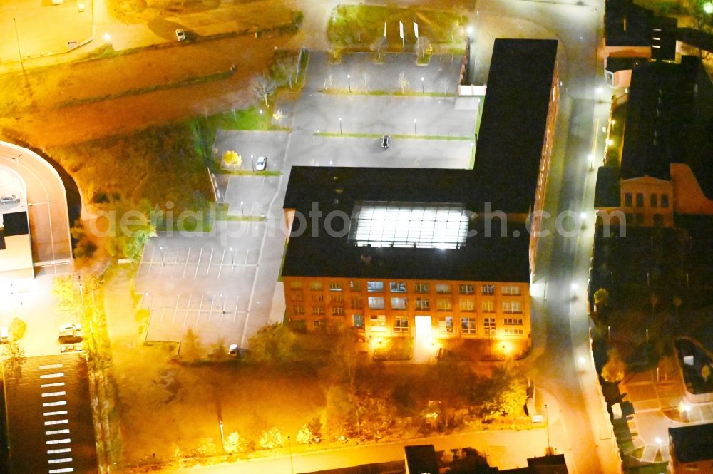 Aerial image at night Dessau - Night lighting administration building of the company of Sitel GmbH in Dessau in the state Saxony-Anhalt, Germany