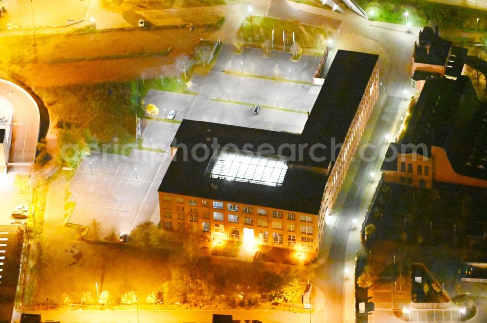 Dessau at night from above - Night lighting administration building of the company of Sitel GmbH in Dessau in the state Saxony-Anhalt, Germany