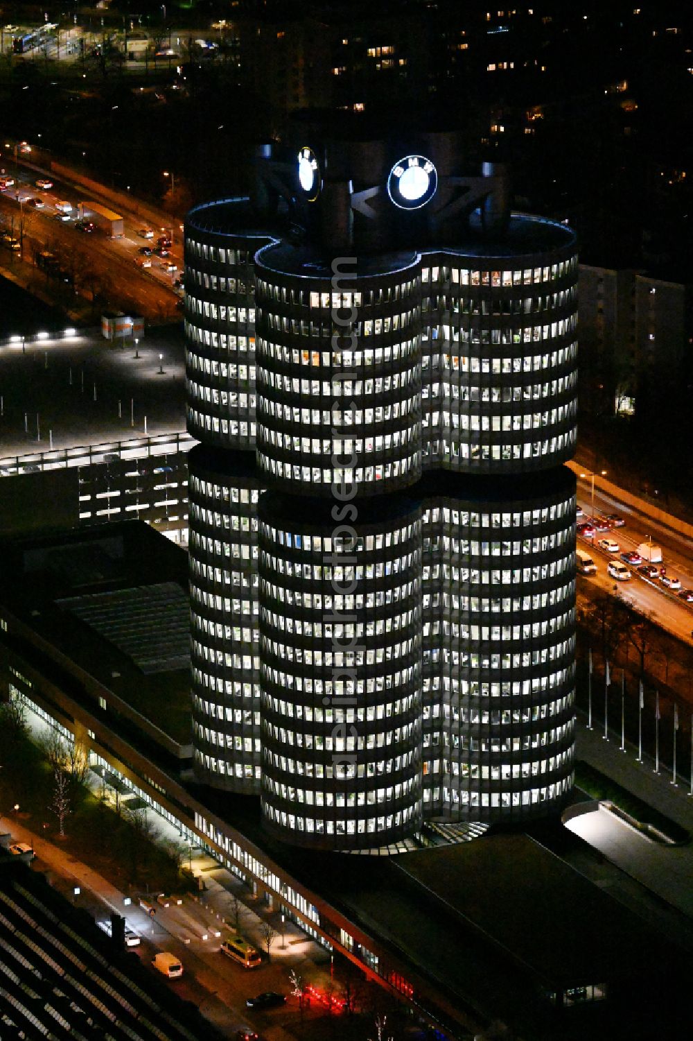 München at night from above - Night lighting administration building of the company Vierzylinof of BMW AG in the district Milbertshofen-Am Hart in Munich in the state Bavaria, Germany