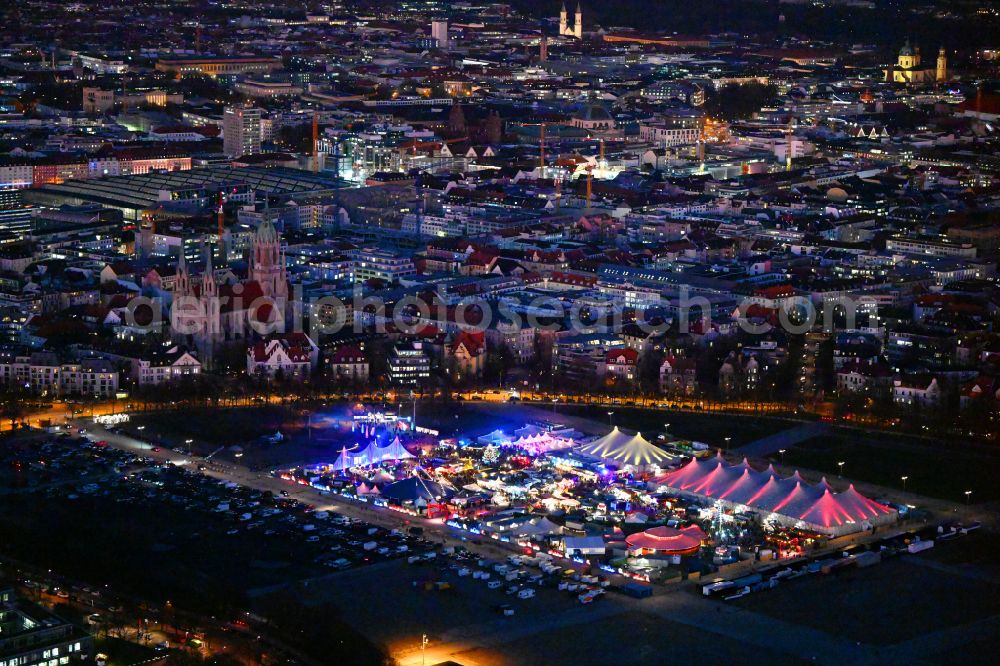 München at night from above - Night lighting christmassy market event grounds and sale huts and booths on Veranstaltungsgelaende of Theresienwiese on street Wirtsbudenstrasse in Munich in the state Bavaria, Germany
