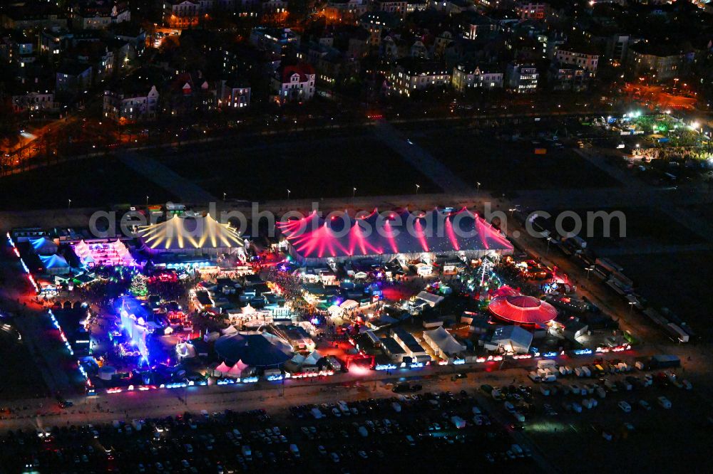 Aerial photograph at night München - Night lighting christmassy market event grounds and sale huts and booths on Veranstaltungsgelaende of Theresienwiese on street Wirtsbudenstrasse in Munich in the state Bavaria, Germany