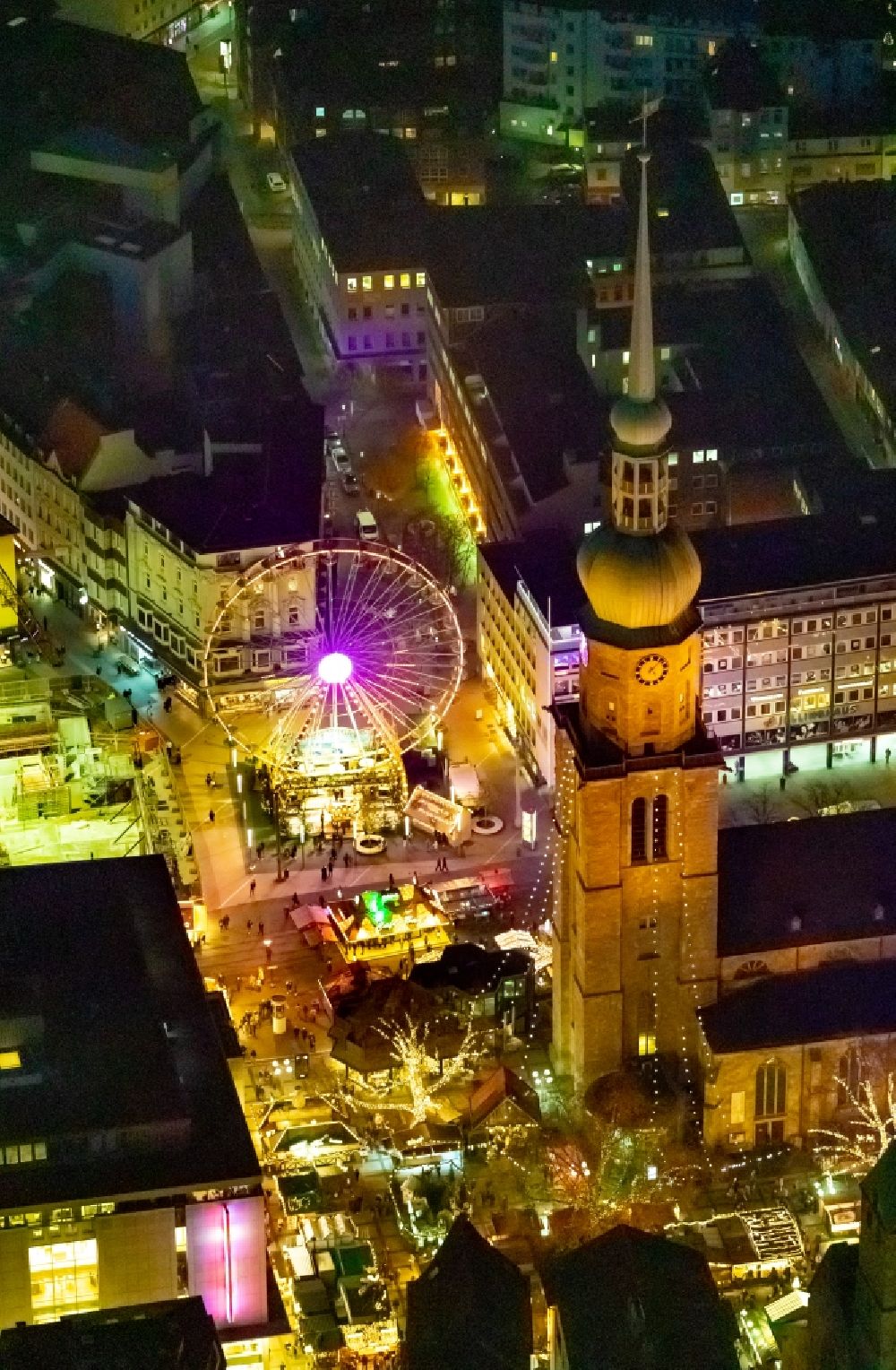 Dortmund at night from the bird perspective: Night lighting christmassy market event grounds and sale huts and booths on Hansaplatz in Dortmund in the state North Rhine-Westphalia, Germany
