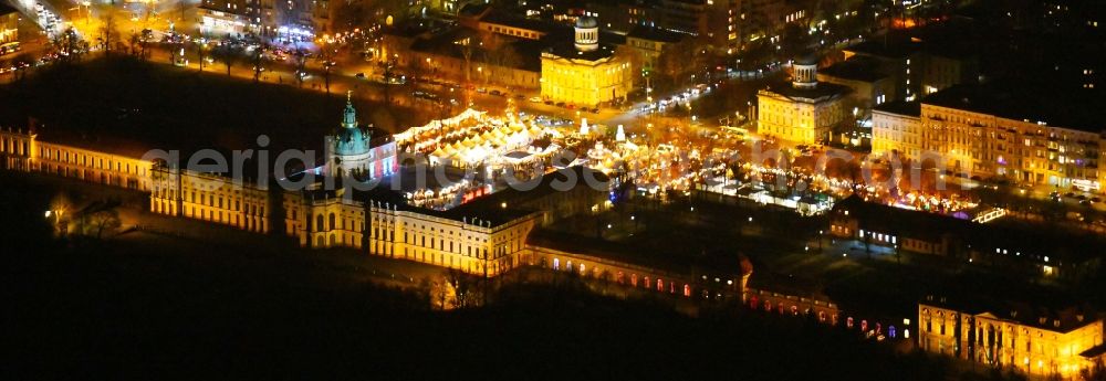 Berlin at night from above - Night lighting Christmassy market event grounds and sale huts and booths on Schloss Charlottenburg in the district Charlottenburg in Berlin, Germany