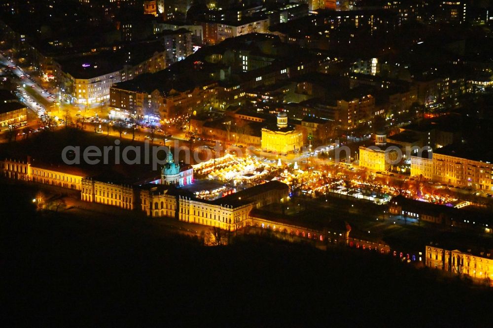 Berlin at night from the bird perspective: Night lighting Christmassy market event grounds and sale huts and booths on Schloss Charlottenburg in the district Charlottenburg in Berlin, Germany