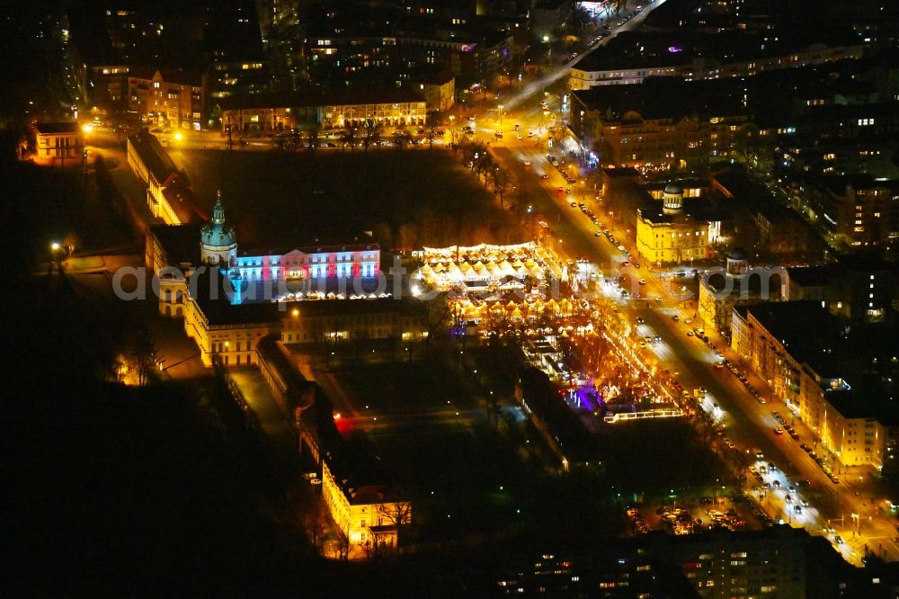 Berlin at night from the bird perspective: Night lighting Christmassy market event grounds and sale huts and booths on Schloss Charlottenburg in the district Charlottenburg in Berlin, Germany