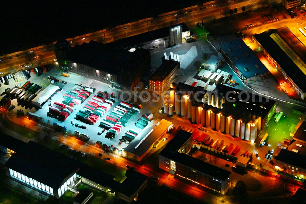 Aerial photograph at night Berlin - Night lighting building and production halls on the premises of the brewery Berliner-Kindl-Schultheiss-Brauerei on Indira-Gandhi-Strasse in the district Hohenschoenhausen in Berlin, Germany