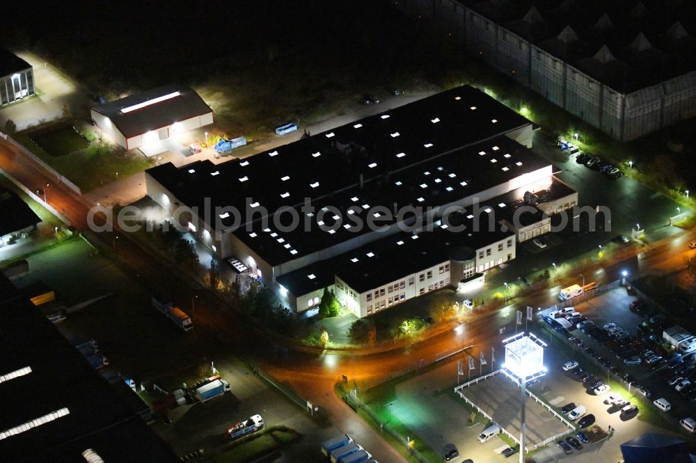 Ahrensfelde at night from the bird perspective: Night lighting buildings and production halls on the factory premises of the offset printing Moeller Druck and Verlag GmbH on Zeppelinstrasse in the district Blumberg in Ahrensfelde in the state Brandenburg, Germany