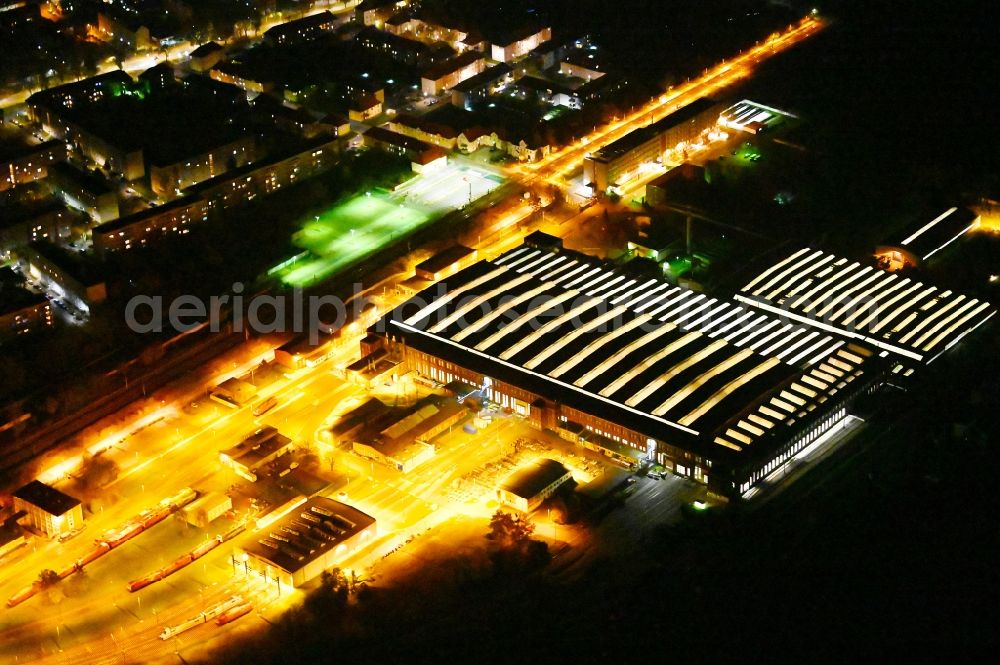 Aerial photograph at night Dessau - Night lighting building and production halls on the premises of DB Fahrzeuginstandhaltung GmbH, factory Dessau on Peterholzstrasse in Dessau in the state Saxony-Anhalt, Germany