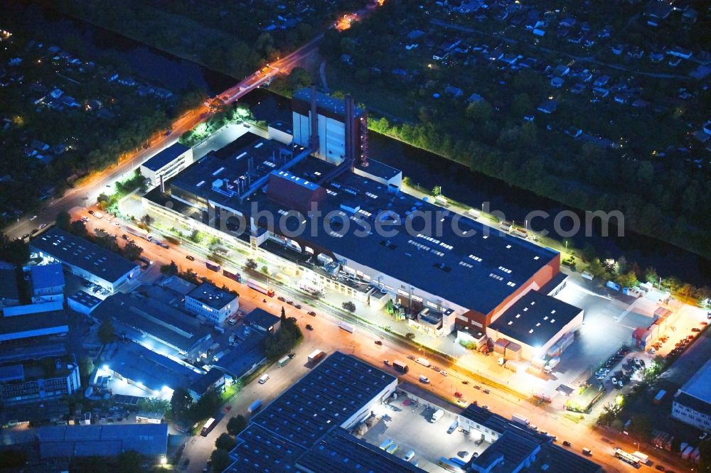 Aerial image at night Berlin - Night lighting building and production halls on the premises of Kaffeegrosshaendler Jacobs Douwe Egberts in Berlin, Germany