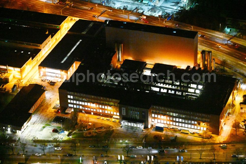 Aerial photograph at night Berlin - Night lighting building and production halls on the premises of Procter & Gamble Manufacturing Berlin GmbH on Oberlandstrasse in the district Tempelhof-Schoeneberg in Berlin, Germany